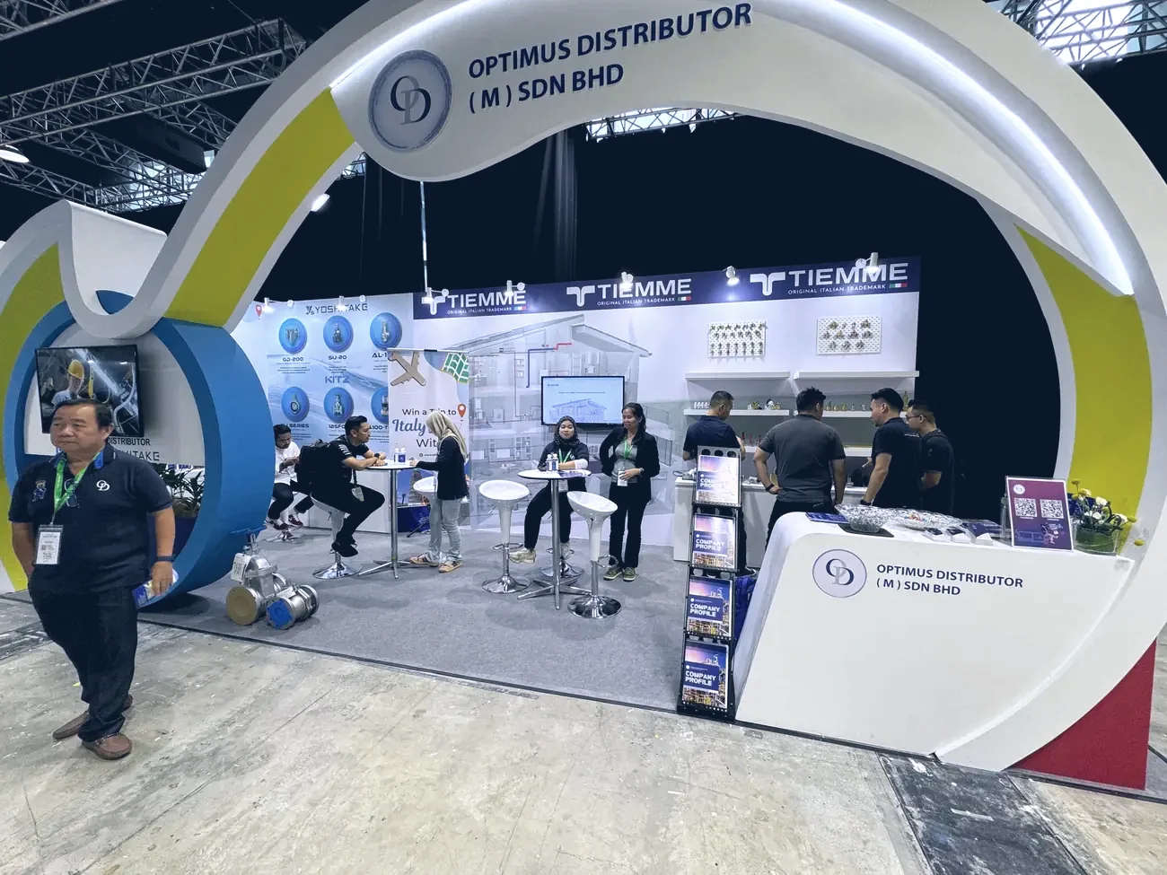The Optimus exhibition booth at a trade show, product ranges on display under the arch