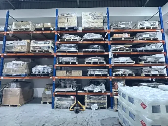 A long shelving run of wrapped and boxed valve stock in the Optimus warehouse at Jalan Tiara 3